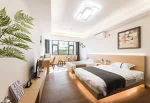 a bedroom with two beds and a dining room with a table at Weisu Service Apartment - Shenzhen Songpingshan Science and Technology Park Store in Shenzhen