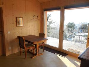 a room with a wooden table and a large window at Studio on Monte Generoso, peace & nature in Castel San Pietro