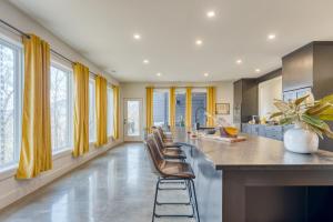 eine Küche mit gelben Vorhängen und einer Theke mit Stühlen in der Unterkunft Dark Horse by AvantStay Hot Tub Balcony Views in Sevierville