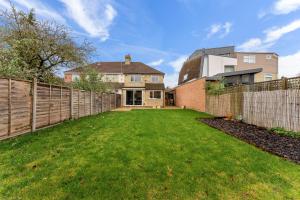 a yard with a fence and a house at Enchanting Abode in Cambridge - Pet Friendly! in Cherry Hinton