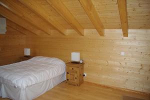 a bedroom with a bed and a wooden wall at Télémark 7 in Zinal