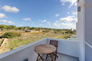 a table and chair on a balcony with a view at A lovely, central 2BR penthouse with large outdoor by 360 Estates in LʼInglin