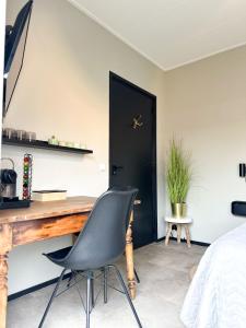 1 dormitorio con escritorio y silla frente a una puerta en Bed & Breakfast Waterpoort - incl licht ontbijt, en Sneek