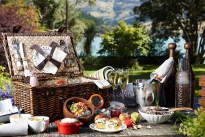 a picnic with a basket and food on a table at Annandale Coastal Farm Escape & Luxury Villa Collection in Akaroa