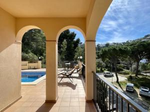 een balkon met uitzicht op een zwembad bij Cala Moreta 44 in Begur