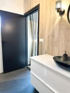 a bathroom with a black door and a sink at Bed & Breakfast Waterpoort - incl licht ontbijt in Sneek