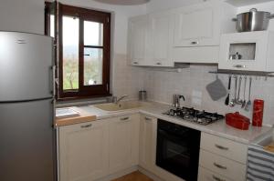 a kitchen with white cabinets and a white refrigerator at La Finestra su Cortona in Cortona