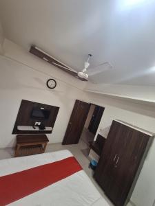 um quarto com uma cama e um relógio na parede em Hotel Nayan palace em Kalol