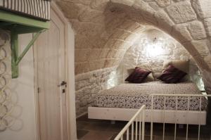 a bedroom with a bed in a stone wall at 30 Metri Quadri in Ostuni