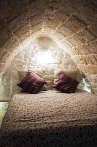 a bed in a brick wall with two pillows on it at 30 Metri Quadri in Ostuni