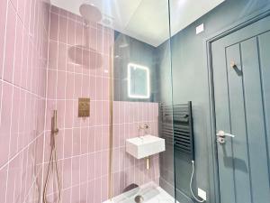a pink tiled bathroom with a sink and a shower at Barbican Loft - with Free parking in York
