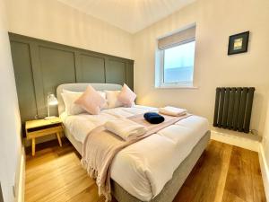 a bedroom with a bed with pillows and a window at Barbican Loft - with Free parking in York
