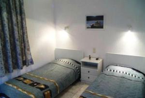 a bedroom with two twin beds and a dresser at Villa Maro in Skopelos Town