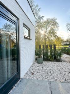 uma porta para um edifício com uma janela e algumas plantas em Bed & Breakfast Waterpoort - incl licht ontbijt em Sneek