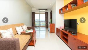 ein Wohnzimmer mit Sofa und Flachbildfernseher in der Unterkunft Lasalle Park Serviced Apartment at Lasalle 75 in Bangna