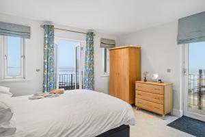 a bedroom with a bed and windows with the ocean at 4 Out Of The Blue, Croyde in Croyde