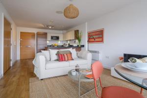 a living room with a white couch and a table at Hauzify I Cavendish flats in West Drayton