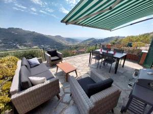 a patio with two couches and a table with a view at Casa Ulivo con Piscina in Diano Castello