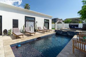 a swimming pool with chairs and a house at Opal by AvantStay Central Scottsdale Luxe Home in Scottsdale