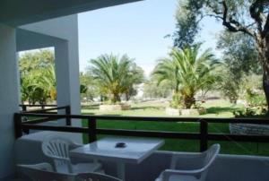a balcony with a table and chairs and trees at Villa Maro in Skopelos Town