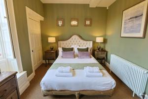 a bedroom with a bed with two towels on it at The Grange in Upper Arley