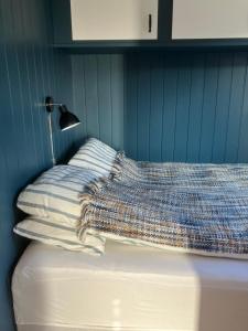 ein Bett mit einer Decke auf dem Zimmer in der Unterkunft Koselig, nyoppusset leilighet in Gjøvik