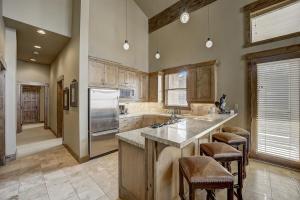 a kitchen with a large island with bar stools at Mont Cervin 32 by AvantStay Ski In Ski Out Home in Silver Lake Village w Hot Tub in Park City
