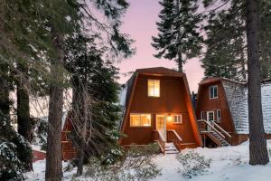 une cabine dans les bois dans la neige dans l'établissement Chickaree by AvantStay A-Frame w Mountain Views, à Tahoe City