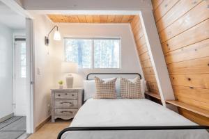 - une chambre avec un lit et un mur en bois dans l'établissement Chickaree by AvantStay A-Frame w Mountain Views, à Tahoe City