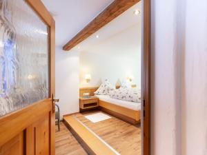 a small bedroom with a bed and a mirror at Haus am Teich - Fewo Relax mit Bergbahn Unlimited in Oberstdorf
