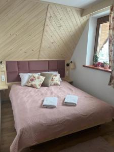 um quarto com uma cama grande com duas toalhas em Apartament Czerwone Wierchy z widokiem na Giewont em Kościelisko