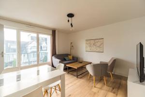 salon z kanapą i stołem w obiekcie 3 bedroom apartment with terrace - Saint-Brieuc w mieście Saint-Brieuc