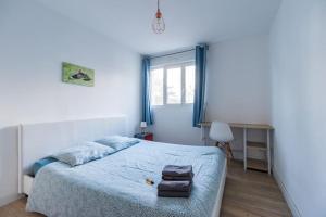 a bedroom with a bed with blue sheets and a window at 3 bedroom apartment with terrace - Saint-Brieuc in Saint-Brieuc