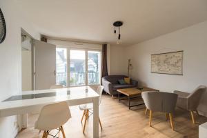 a living room with a table and chairs and a couch at 3 bedroom apartment with terrace - Saint-Brieuc in Saint-Brieuc