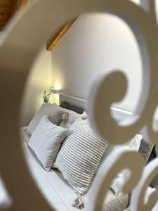 um quarto com uma cama com almofadas e um espelho em Mansarda antica Milano em San Giuliano Milanese