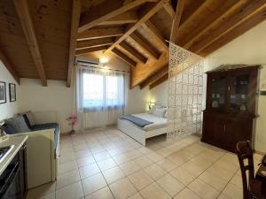 a living room with a bed and a kitchen at Mansarda antica Milano in San Giuliano Milanese