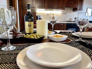 a table with a white plate and wine glasses at Mansarda antica Milano in San Giuliano Milanese