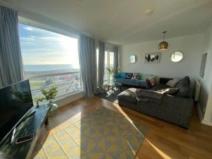 a living room with a couch and a large window at Central Sea View maisonette in Hastings