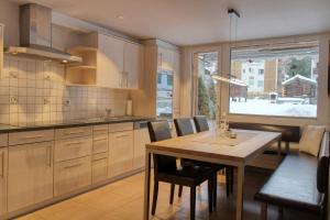 cocina con mesa, sillas y ventana en Matterhorngruss Apartments, en Zermatt