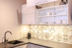 a kitchen with white cabinets and a sink at Boutique Apartment 23 in Jáchymov