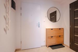 a bedroom with a wooden dresser and a mirror at Boutique Apartment 23 in Jáchymov