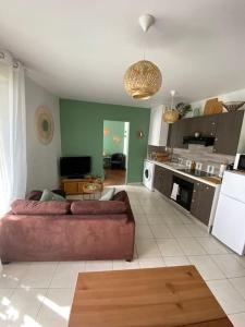 uma sala de estar com um sofá e uma cozinha em Appartement centre-ville proche de Paris. em Limay
