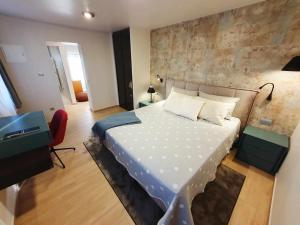 a bedroom with a large bed and a red chair at NEW Ana Design City Center Apartments in Pula