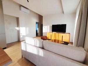 a living room with a couch and a flat screen tv at NEW Ana Design City Center Apartments in Pula