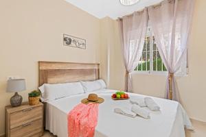 a bedroom with a white bed with a hat and towels at Apartamento Casita Blanca - PlusHolidays in Calpe