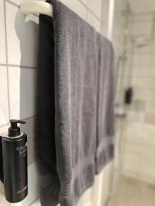 a black soap dispenser on a towel rack in a bathroom at Hotell Garvaren in Ljungby