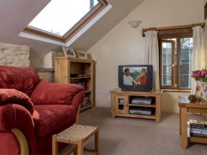 a living room with a red couch and a tv at 1 Bed in Bwlch BN367 in Bwlch