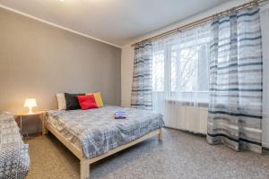 um quarto com uma cama e uma grande janela em 4 can stay Free parking Self CheckIn Center-9 min. em Riga