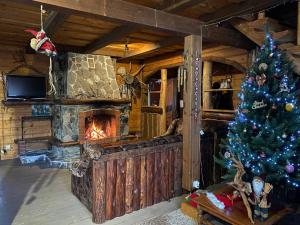 a christmas tree in a living room with a fireplace at Ранчо в Карпатах in Bukovel