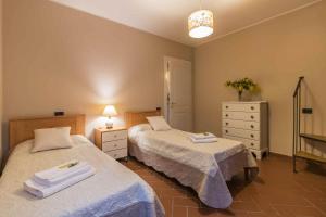 een slaapkamer met twee bedden en een ladekast bij Casa Amedeo in Lucca